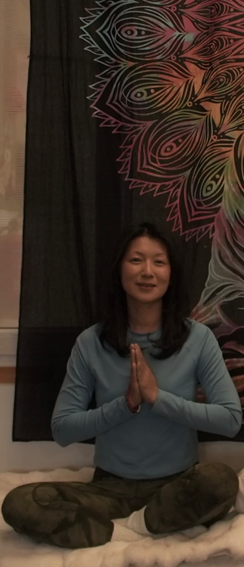 Jigme Wangmo seated in meditation with hands in prayer