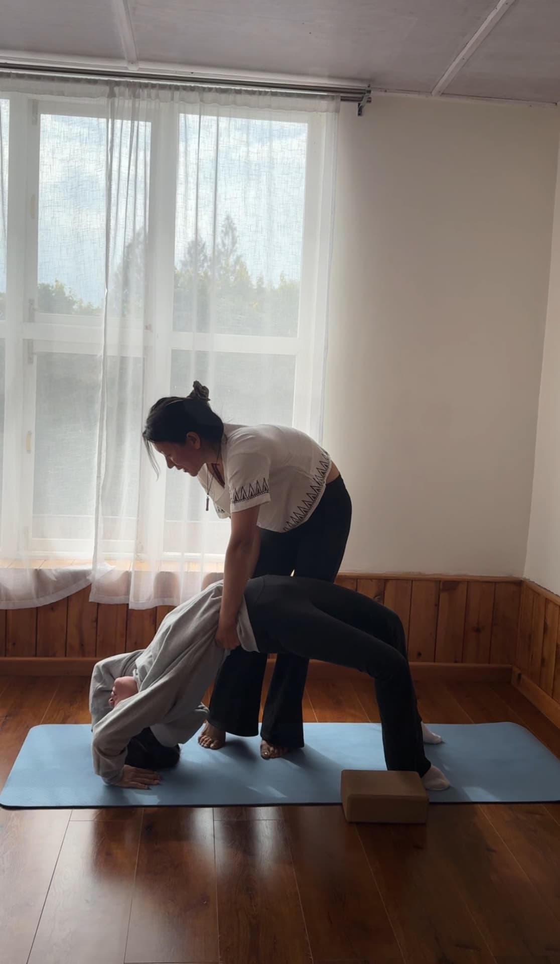 Jigme giving a hands-on adjustment during a yoga class