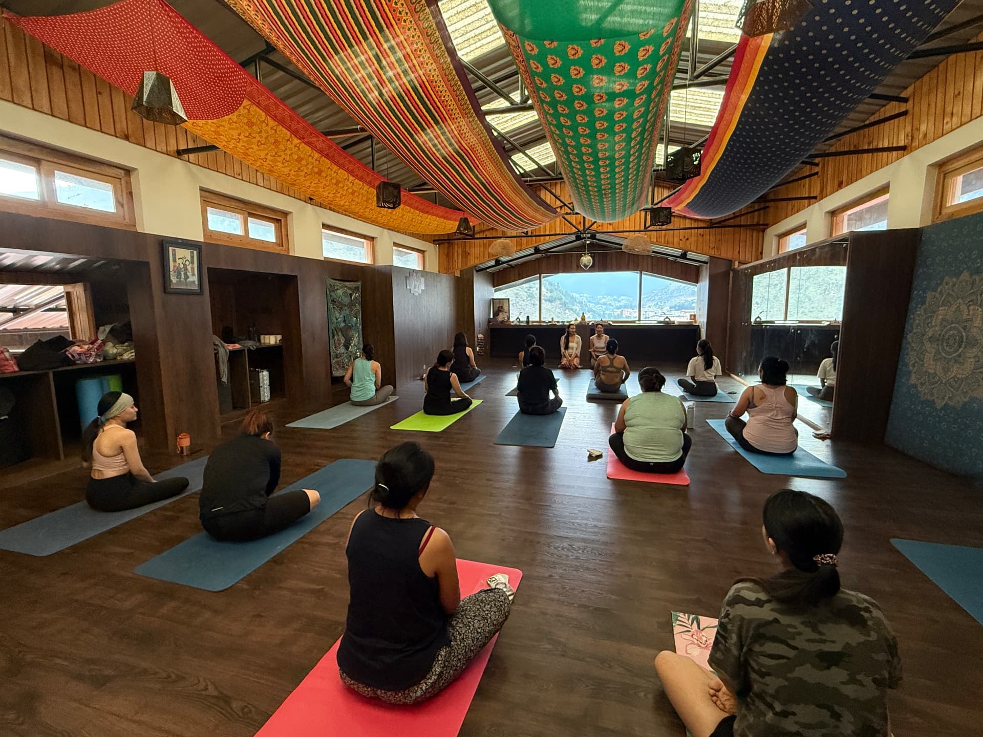 A group seated on mats in the yoga hall
