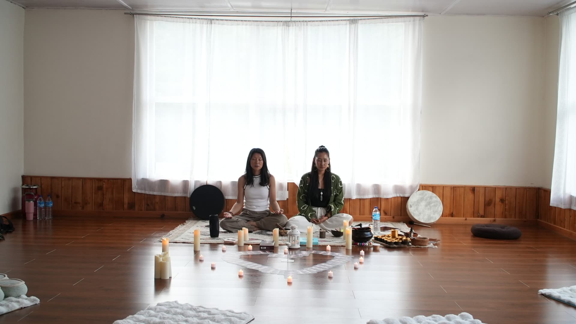 Tshering and Jigme meditating in a candle-lit hall in Bhutan